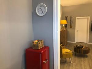 una habitación con un reloj en la pared y una maleta roja en Claire et Liège, toute une histoire..., en Lieja