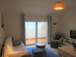 a living room with a couch and a view of a patio at Casas do Mar - Baleal 2 - Sea House in Baleal