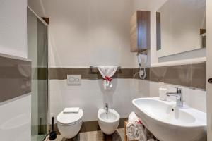 bagno con servizi igienici bianchi e lavandino di Mamo Florence - Fiesolana Apartments a Firenze