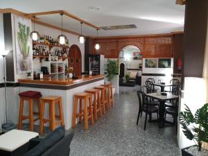 a restaurant with a bar with wooden stools at Pension los Verdiales in La Herradura