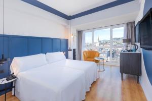 a hotel room with a large white bed and a window at Hotel San Sebastián Orly, Affiliated by Meliá in Donostia-San Sebastián
