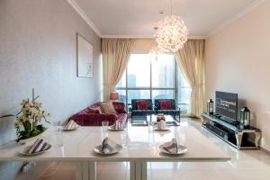sala de estar con mesa y sofá en Quintessential Quarters - Breathtaking 29th Floor Views, en Dubái