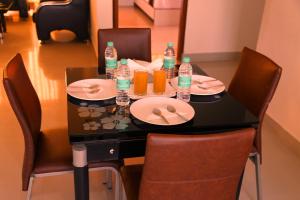 a table with plates and bottles of orange juice at Airport Gateway Hotel in Devanhalli