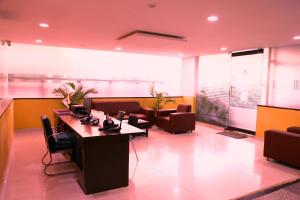 a waiting room with chairs and tables in a building at Airport Gateway Hotel in Devanhalli
