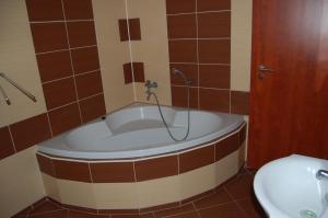 a bath tub in a bathroom with a toilet at Penzion u můstku Jiřího Rašky in Trojanovice