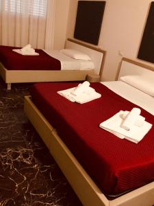 2 camas con toallas y servilletas en una habitación en Emme B&B, en Messina