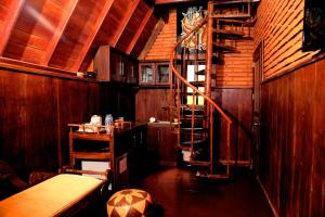 a wooden room with a spiral staircase and a table at D Family Resort in Anuradhapura