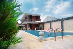 a swimming pool in front of a house at D Family Resort in Anuradhapura