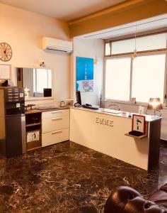een keuken met een aanrecht met een wastafel en een magnetron bij Emme B&B in Messina