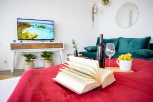 een open boek op een tafel met wijnglazen en een televisie bij Modernes Apartment mit tollem Blick über die Stadt in Augsburg