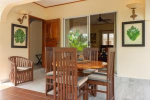 a dining room with a wooden table and chairs at Villa Aya in Grand'Anse Praslin