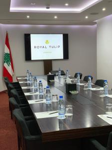 uma sala de conferências com uma mesa longa com garrafas de água em Royal Tulip Achrafieh em Beirute mais 111 fotografias