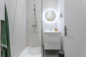 uma casa de banho branca com um lavatório e um espelho em Le Cocon Lita-Palace em Lyon
