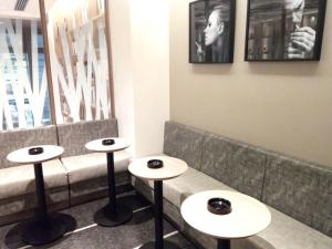 a row of tables in a restaurant with a bench at HOTEL Cargo Shinsaibashi in Osaka