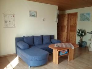 a living room with a blue couch and a table at Seeidyll in Zemitz