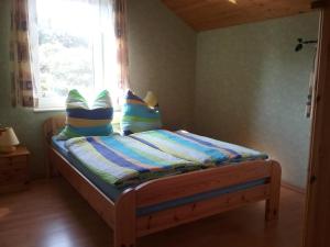 a bedroom with a bed with pillows and a window at Seeidyll in Zemitz