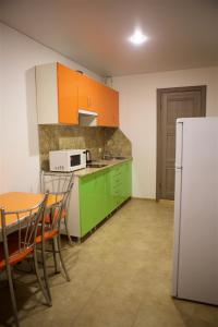 a kitchen with green cabinets and a white refrigerator at Guest House Bereg in Anapa