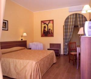 アルベロベッロにあるホテル クオール ディ プーリア のベッドとテーブルが備わるホテルルームです。