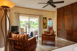 a living room with a couch and a ceiling fan at Villa Aya in Grand'Anse Praslin
