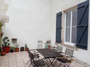 a patio with a wooden table and chairs and a window at la maison de Valbois in Varvinay