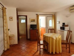 ein Wohnzimmer mit einem Tisch und einer Küche in der Unterkunft Casa da Mae in Salir