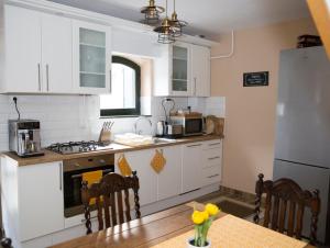 uma cozinha com electrodomésticos brancos e uma mesa com cadeiras em Antalóczy Vendégház em Tokaj