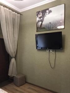 einen Flachbild-TV an einer Wand mit einem Vorhang in der Unterkunft Hostel Q ,15 хв до жд вокзалу in Lwiw