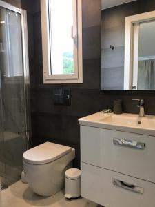 a bathroom with a toilet and a sink and a mirror at Nuevo Luminoso Apartamento Catalina a 80 metros de la playa para 4 personas in Sant Feliu de Guixols