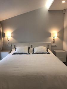a bedroom with a large white bed with two pillows at Nuevo Luminoso Apartamento Catalina a 80 metros de la playa para 4 personas in Sant Feliu de Guixols