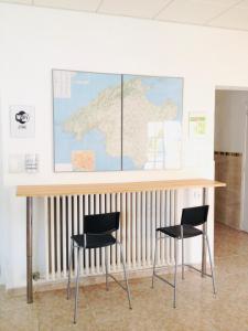 una scrivania con 2 sedie e una mappa sul muro di Hostal San Telmo a Palma de Mallorca