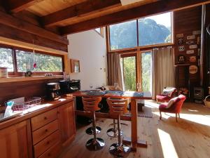 - une cuisine avec une table, des chaises et des fenêtres dans l'établissement The Loft, à Las Trancas