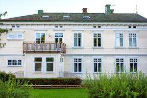 Una gran casa blanca con balcón. en Vänersborgs Vandrarhem en Vänersborg