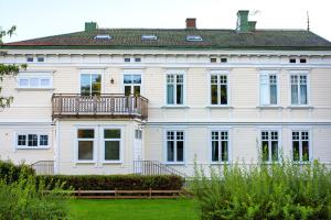 a large white house with a balcony on it at Vänersborgs Vandrarhem in Vänersborg