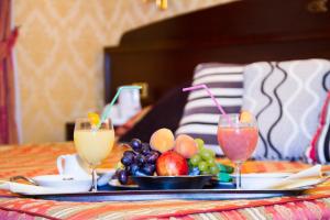 una bandeja de fruta en una mesa con dos bebidas en Grand Hotel Dei Cesari, en Anzio