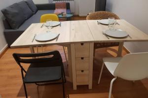 a table with two plates and glasses on top of it at Cosy home near Paris in Gagny