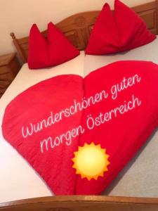 a red heart shaped blanket on a bed at vidimo se in Selzthal