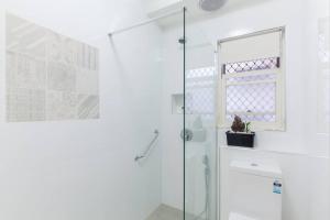 a bathroom with a glass shower stall and a cat in a plant at B3 Crawley Apartment 1 BRM & Sleepout near UWA in Perth +26 photos