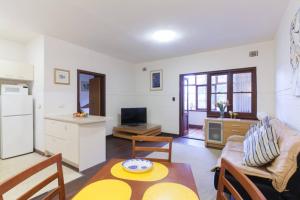 a kitchen and a living room with a table and chairs at B3 Crawley Apartment 1 BRM & Sleepout near UWA in Perth
