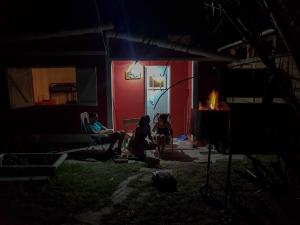 un grupo de personas sentadas fuera de una casa por la noche en La Casita de Monte en Monte Hermoso