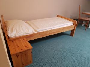 drewnianym łóżkiem w pokoju ze stołem i krzesłem w obiekcie Gasthof s'Schatzkastl w mieście Ardagger Markt