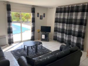 a living room with a couch and a table and a tv at Detached villa in a beautiful area in La Croix-Blanche