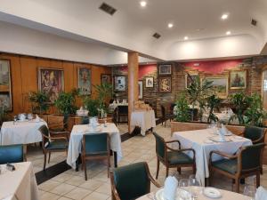 restauracja z białymi stołami, krzesłami i roślinami w obiekcie Hotel Chef Rivera w mieście Padrón