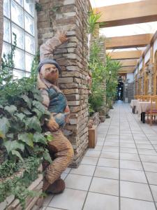 posąg człowieka opierającego się o ścianę w obiekcie Hotel Chef Rivera w mieście Padrón