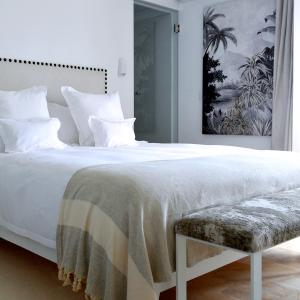 a bedroom with a large white bed with a bench at VILLA EDO in Gammarth