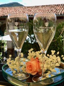 two wine glasses sitting on a table with flowers at Villa Redona in Entratico