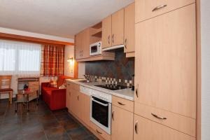 a kitchen with a stove top oven next to a living room at Haus Handle in Kappl