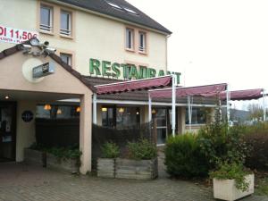 a restaurant with a sign on the side of a building at Hôtel Motelia in Moissy-Cramayel