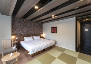 1 dormitorio con 1 cama grande y 1 mesa en 谷町君・ホテルひとめぼれ 京都四条烏丸, en Kioto