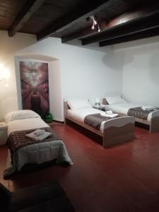 a bedroom with two beds and a painting on the wall at Divino Suite 2.0 in Bergamo