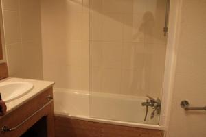y baño con bañera blanca y lavamanos. en Chalet cosy Duplex 6 personnes, en Saint-Sorlin-dʼArves